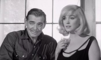 Movie still from “The Misfits” (1961), directed by John Huston – An older man and a young woman posing for a picture; Close Up shot, Over the shoulder angle