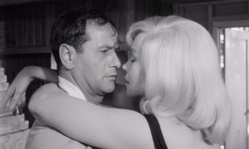 Movie still from “The Misfits” (1961), directed by John Huston – An older man and a younger woman kissing each other; Close Up shot, Low angle