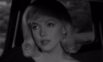 Movie still from “The Misfits” (1961), directed by John Huston – A black - and - white photo of a woman with blonde hair; Close Up shot, Over the shoulder angle