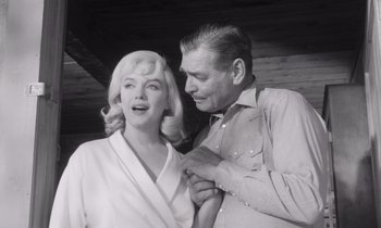 Movie still from “The Misfits” (1961), directed by John Huston – An old photo of a man and a woman; Medium shot, Low angle