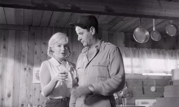 Movie still from “The Misfits” (1961), directed by John Huston – A man and a woman standing next to each other in a kitchen; Medium shot, Low angle