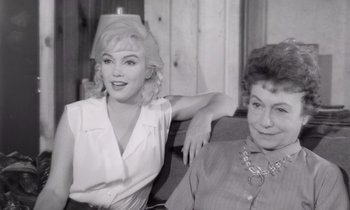 Movie still from “The Misfits” (1961), directed by John Huston – Two women sitting next to each other on a couch; Medium shot, Over the shoulder angle