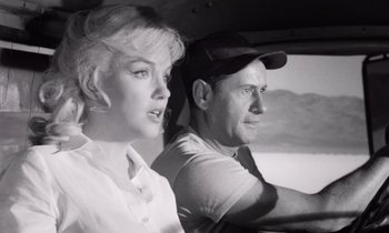 Movie still from “The Misfits” (1961), directed by John Huston – A man and a woman sitting in the back of a car; Medium shot, Low angle