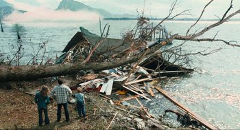 Movie still from “The Mist” (2007), directed by Frank Darabont – Two men standing next to a pile of debris on the side of a lake; Extreme Wide shot, High angle