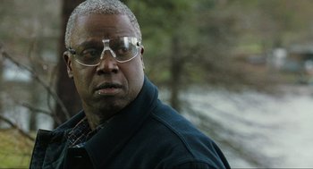 Movie still from “The Mist” (2007), directed by Frank Darabont – An older man wearing glasses and a black jacket; Close Up shot, Over the shoulder angle