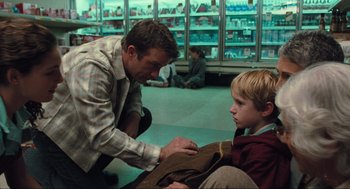 Movie still from “The Mist” (2007), directed by Frank Darabont – A man and a boy are sitting in a store; Medium shot, Over the shoulder angle