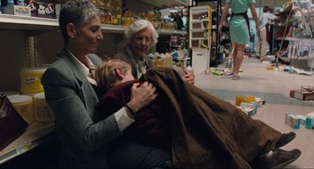 Movie still from “The Mist” (2007), directed by Frank Darabont – Two women and a child sitting on the floor; Wide shot, Over the shoulder angle
