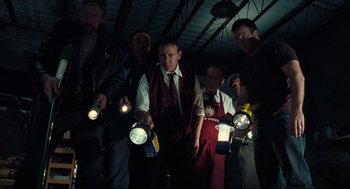 Movie still from “The Mist” (2007), directed by Frank Darabont – A group of men standing next to each other holding lights; Medium shot, Low angle