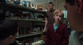 Movie still from “The Mist” (2007), directed by Frank Darabont – A man and a boy standing in front of shelves of food; Medium shot, Over the shoulder angle