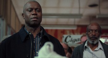 Movie still from “The Mist” (2007), directed by Frank Darabont – A man standing in front of other people; Medium shot, Low angle