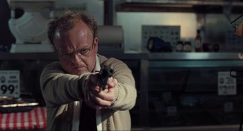 Movie still from “The Mist” (2007), directed by Frank Darabont – A man holding a gun in a room; Close Up shot, Low angle