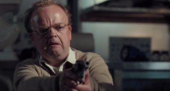 Movie still from “The Mist” (2007), directed by Frank Darabont – A man holding a gun while wearing glasses and a sweater; Close Up shot, Low angle