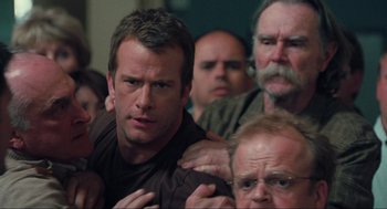 Movie still from “The Mist” (2007), directed by Frank Darabont – A group of men standing next to each other in a room; Close Up shot, Over the shoulder angle