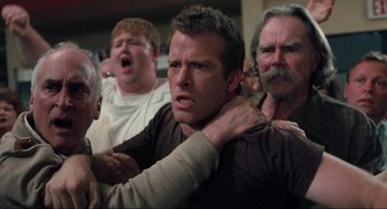 Movie still from “The Mist” (2007), directed by Frank Darabont – A group of men standing next to each other in a room; Medium shot, Low angle