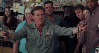 Movie still from “The Mist” (2007), directed by Frank Darabont – A group of people standing in a room; Medium shot, Low angle