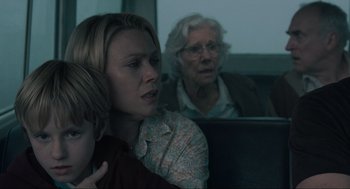Movie still from “The Mist” (2007), directed by Frank Darabont – A woman holding a child in front of an older woman; Close Up shot, Over the shoulder angle