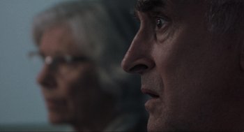 Movie still from “The Mist” (2007), directed by Frank Darabont – A man's face with a woman in the background; Extreme Close Up shot, Over the shoulder angle
