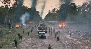 Movie still from “The Mist” (2007), directed by Frank Darabont – A group of military vehicles driving down a dirt road; Extreme Wide shot, High angle