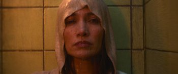 Movie still from “The Mother” (2023), directed by Niki Caro – A person wearing a hooded sweatshirt; Close Up shot, High angle
