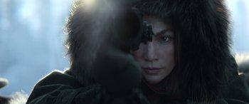 Movie still from “The Mother” (2023), directed by Niki Caro – A person holding a gun; Close Up shot, Over the shoulder angle
