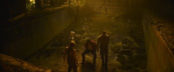 Movie still from “The Mother” (2023), directed by Niki Caro – A group of people standing in a field at night; Wide shot, High angle