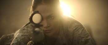 Movie still from “The Mother” (2023), directed by Niki Caro – A woman is looking through a rifle scope at the camera; Close Up shot, Over the shoulder angle