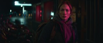 Movie still from “The Mother” (2023), directed by Niki Caro – A woman with a backpack standing in the dark at night; Close Up shot, Over the shoulder angle