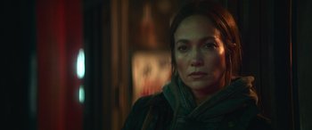 Movie still from “The Mother” (2023), directed by Niki Caro – A person wearing a jacket; Close Up shot, Over the shoulder angle