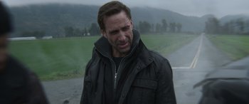 Movie still from “The Mother” (2023), directed by Niki Caro – A person wearing a black jacket; Close Up shot, Low angle