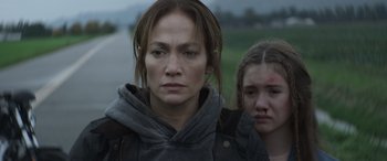 Movie still from “The Mother” (2023), directed by Niki Caro – A woman and a young girl standing next to each other; Close Up shot, Over the shoulder angle