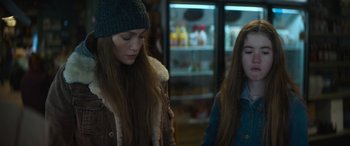 Movie still from “The Mother” (2023), directed by Niki Caro – A woman and a girl standing next to each other in front of a refrigerator; Close Up shot, Over the shoulder angle