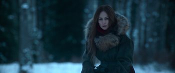 Movie still from “The Mother” (2023), directed by Niki Caro – A woman with long red hair wearing a coat; Medium shot, Over the shoulder angle