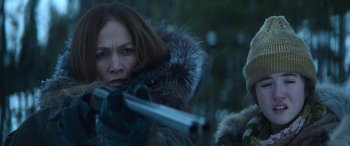 Movie still from “The Mother” (2023), directed by Niki Caro – A woman holding a gun while another woman holds a gun; Close Up shot, Over the shoulder angle