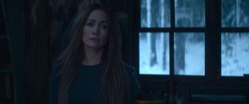 Movie still from “The Mother” (2023), directed by Niki Caro – A woman standing in front of an open window; Medium shot, Over the shoulder angle