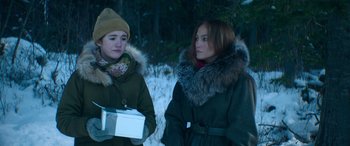 Movie still from “The Mother” (2023), directed by Niki Caro – Two people standing next to each other in the snow; Medium shot, Over the shoulder angle