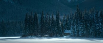 Movie still from “The Mother” (2023), directed by Niki Caro – A cabin in the middle of a snowy forest; Extreme Wide shot, High angle