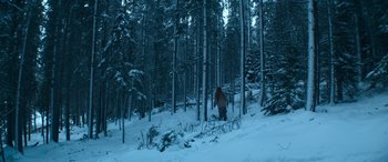 Movie still from “The Mother” (2023), directed by Niki Caro – A person walking through the snow; Extreme Wide shot, High angle