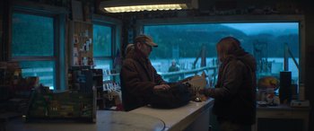 Movie still from “The Mother” (2023), directed by Niki Caro – A man sitting at the counter of a restaurant; Wide shot, Over the shoulder angle