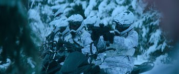 Movie still from “The Mother” (2023), directed by Niki Caro – A group of men in white suits and helmets are sitting on motorcycles; Wide shot, Over the shoulder angle