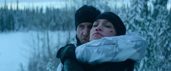 Movie still from “The Mother” (2023), directed by Niki Caro – A man and a woman hugging in the snow; Close Up shot, Over the shoulder angle