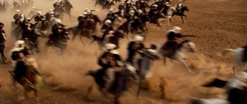 Movie still from “The Mummy” (1999), directed by Stephen Sommers – A large group of people on horses in the dirt; Extreme Wide shot, High angle