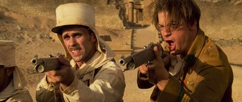 Movie still from “The Mummy” (1999), directed by Stephen Sommers – Two men are holding guns in the desert; Close Up shot, Low angle