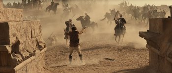 Movie still from “The Mummy” (1999), directed by Stephen Sommers – A group of men on horses are fighting in the sand; Extreme Wide shot, High angle