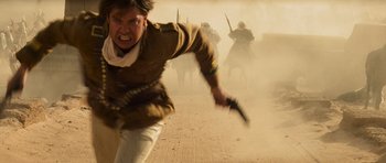 Movie still from “The Mummy” (1999), directed by Stephen Sommers – An image of a man running in the dust; Medium shot, Low angle