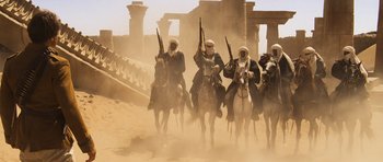 Movie still from “The Mummy” (1999), directed by Stephen Sommers – A group of men riding horses in the desert; Wide shot, Low angle