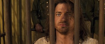 Movie still from “The Mummy” (1999), directed by Stephen Sommers – A person with long hair in a jail cell; Close Up shot, Over the shoulder angle