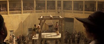 Movie still from “The Mummy” (1999), directed by Stephen Sommers – Two men are standing on a wooden platform and one is holding a rope; Extreme Wide shot, High angle