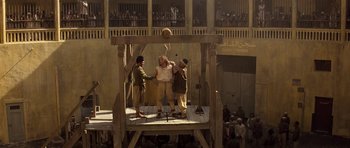 Movie still from “The Mummy” (1999), directed by Stephen Sommers – A group of people on a stage playing a game; Extreme Wide shot, High angle