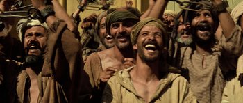 Movie still from “The Mummy” (1999), directed by Stephen Sommers – A group of men standing next to each other laughing; Medium shot, Low angle
