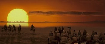 Movie still from “The Mummy” (1999), directed by Stephen Sommers – A group of people riding horses on a beach; Extreme Wide shot, High angle